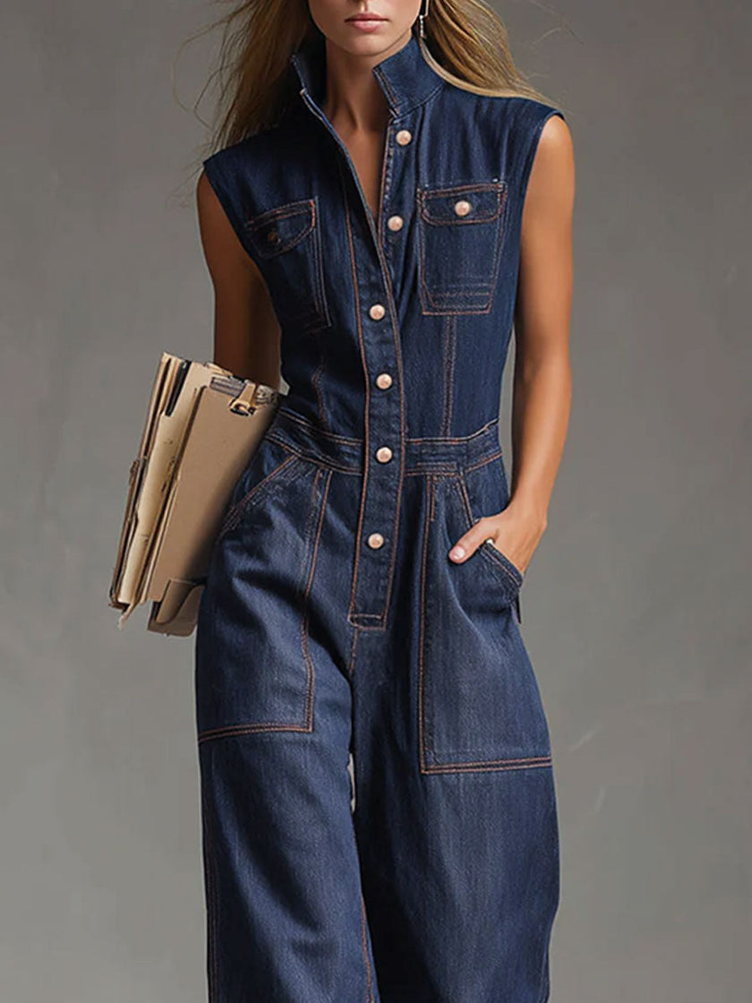 Dark blue denim FJØRNA jumpsuit with multi-pocket design, sleeveless balloon style, and relaxed fit.
