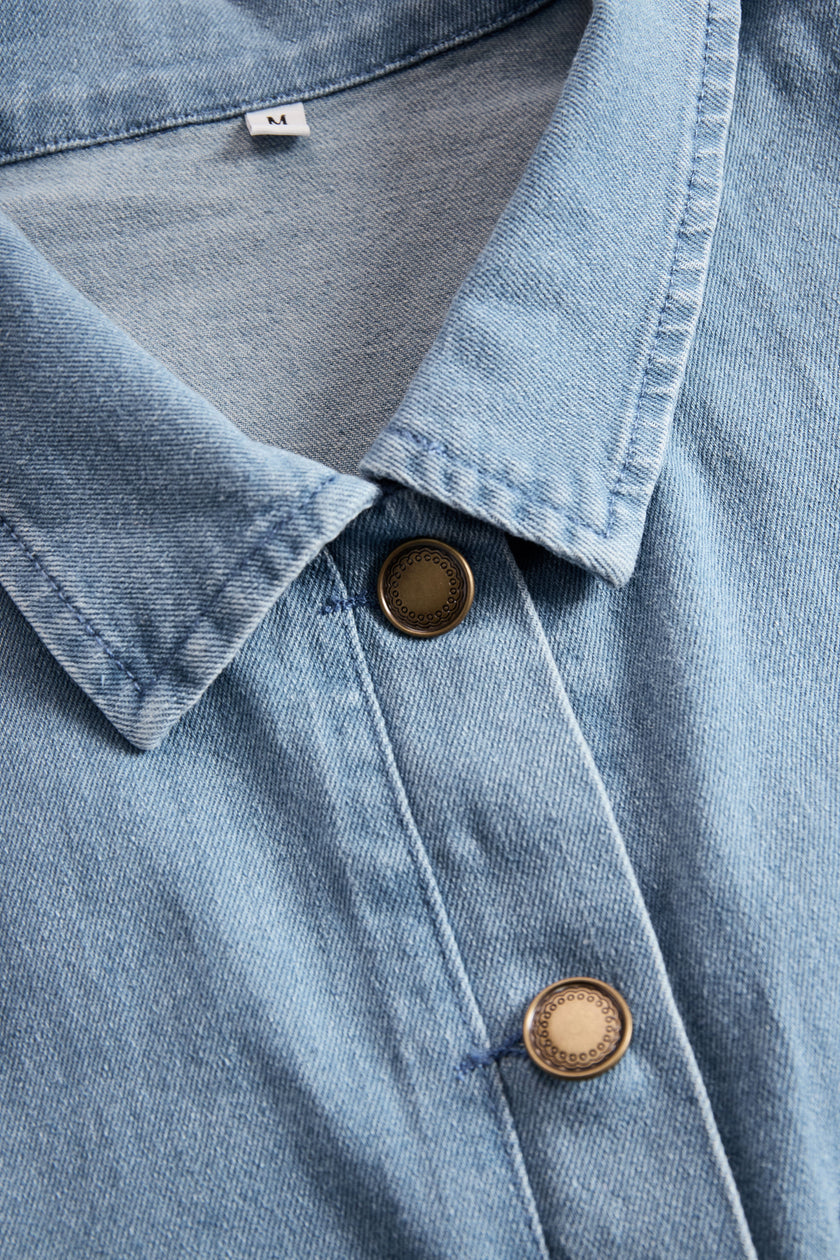 Light blue denim sleeveless jumpsuit with raw edge details and wide-leg design from FJØRNA, shown on a model.
