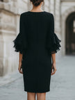 FJØRNA black dress with ruffled sheer sleeves, elegant and stylish for formal occasions, close-up of the dress's design details.