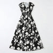 Women's floral print V-neck summer maxi dress by FJØRNA, flowing fabric with vibrant floral pattern and sleeveless design.