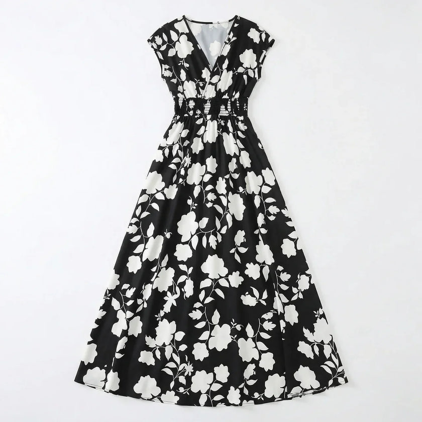 Women's floral print V-neck summer maxi dress by FJØRNA, flowing fabric with vibrant floral pattern and sleeveless design.