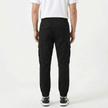Men's slim fit cotton cargo trousers by FJØRNA, shown in dark green with multiple pockets and a tapered leg fit.