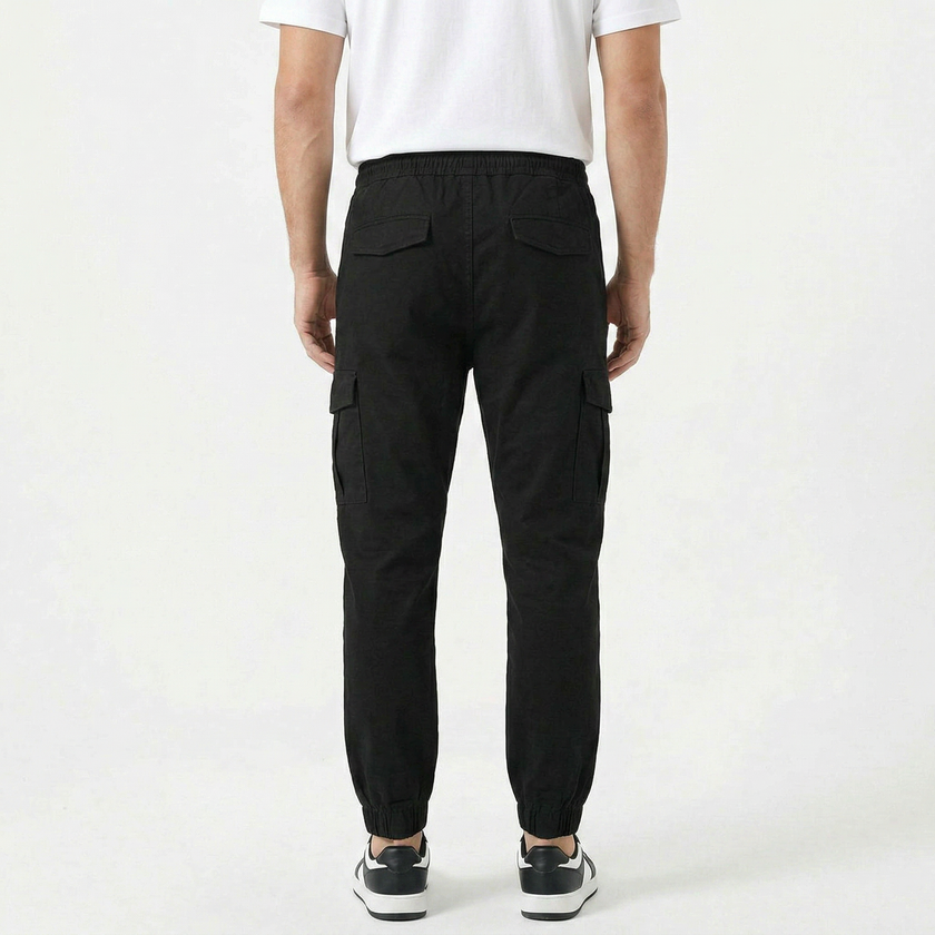 Men's slim fit cotton cargo trousers by FJØRNA, shown in dark green with multiple pockets and a tapered leg fit.