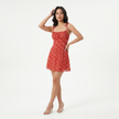 Women's floral print tie strap mini dress by FJØRNA, featuring a colorful floral pattern and a stylish tie strap design.