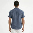 Men's FJØRNA cotton-linen short sleeve shirt, light fabric with a casual fit and button-up front, displayed on a hanger.