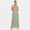 FJØRNA women's sleeveless halter neck summer maxi dress with flowing fabric and vibrant floral pattern.