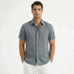 Men's FJØRNA cotton-linen short sleeve shirt displayed on a hanger, featuring a casual design with a button-up front and collar.