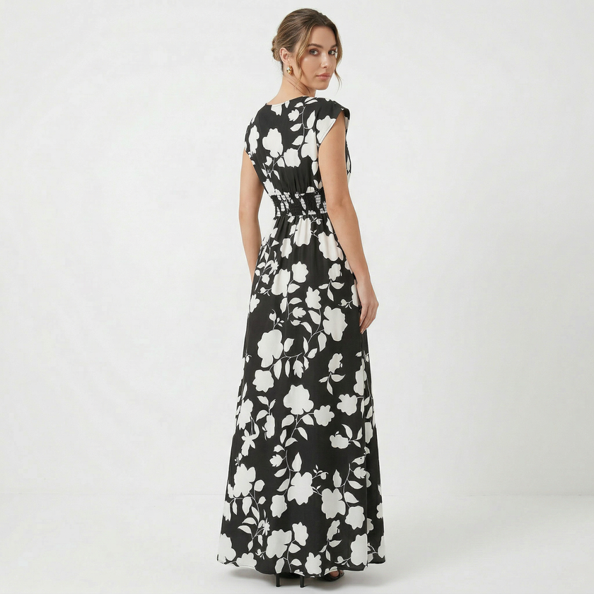 Women's floral print V-neck summer maxi dress by FJØRNA, flowing fabric with vibrant floral pattern and sleeveless design.