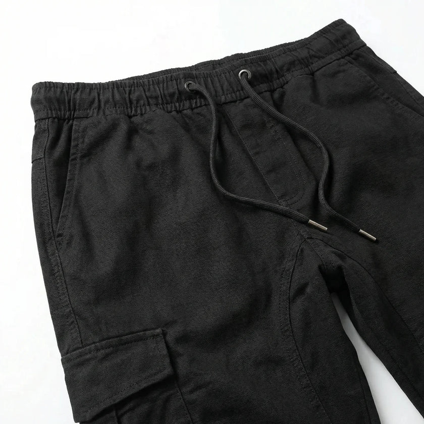 Men's slim fit cotton cargo trousers by FJØRNA, showcasing the relaxed fit, multiple cargo pockets, and classic khaki color.