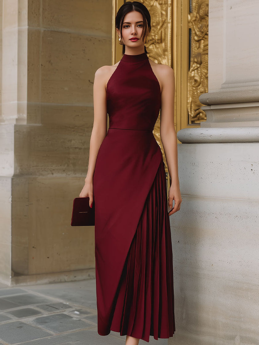 FJØRNA burgundy halter-neck asymmetric pleated midi dress, featuring a flowy design and elegant midi length.