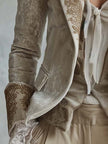 Ivory velvet blazer with intricate embroidery and lace cuffs, long sleeve style by FJØRNA, shown on a model.