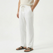 Men's FJØRNA linen drawstring trousers with relaxed fit and lightweight fabric, shown in a casual style.