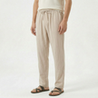 Men's linen drawstring trousers by FJØRNA, featuring a relaxed fit and adjustable waistband, shown in a neutral color.