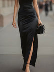 Black satin halter neck slit gown by FJØRNA, elegant black maxi dress with a flowing silhouette and stylish slit detail.