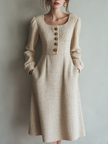 FJØRNA vintage tweed button long sleeve midi dress displayed on a hanger, showcasing classic pattern and elegant design.