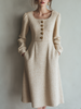 FJØRNA vintage tweed button long sleeve midi dress displayed on a hanger, showcasing classic pattern and elegant design.