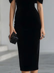 FJØRNA black velvet midi dress for women with a dramatic bow detail, elegant and stylish for formal occasions.
