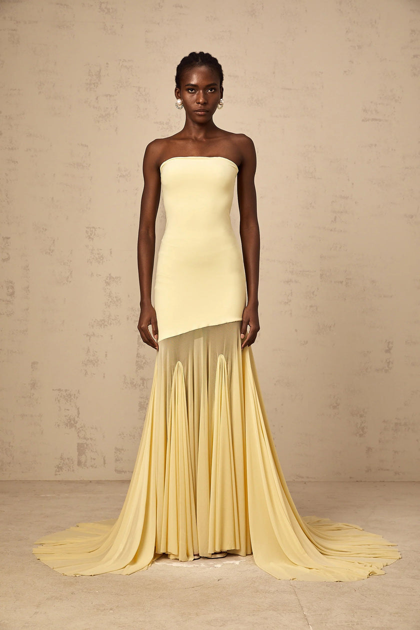 FJØRNA Josiane yellow off-shoulder sheer tulle maxi dress displayed on a model, featuring flowing fabric and elegant off-shoulder design.