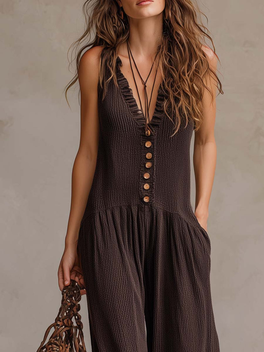 Brown FJØRNA sleeveless ruffle neck knitted jumpsuit with retro style and ruffle details, displayed on a mannequin.