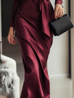 FJØRNA Burgundy satin wrap dress with waist tie detail, featuring a timeless elegant design and smooth satin fabric.