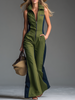 Green FJØRNA sleeveless jumpsuit with stand collar and zip-up front, positioned on a hanger with a clean background.