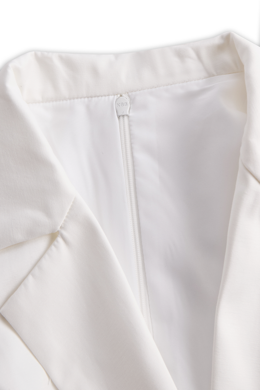 White pleated mini shirt dress by FJØRNA featuring a classic collar, button front, and flowing pleated skirt.