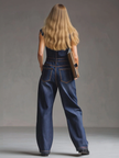 Dark blue denim FJØRNA sleeveless jumpsuit with multi-pocket design and balloon silhouette, featuring a relaxed fit.