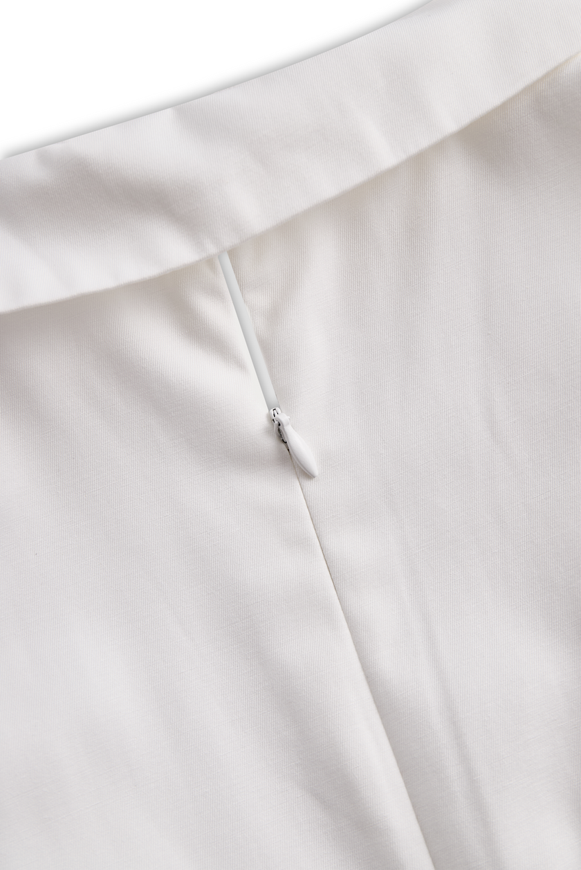White FJØRNA pleated mini shirt dress with a collared neckline and short sleeves, styled with a flowing, feminine silhouette.