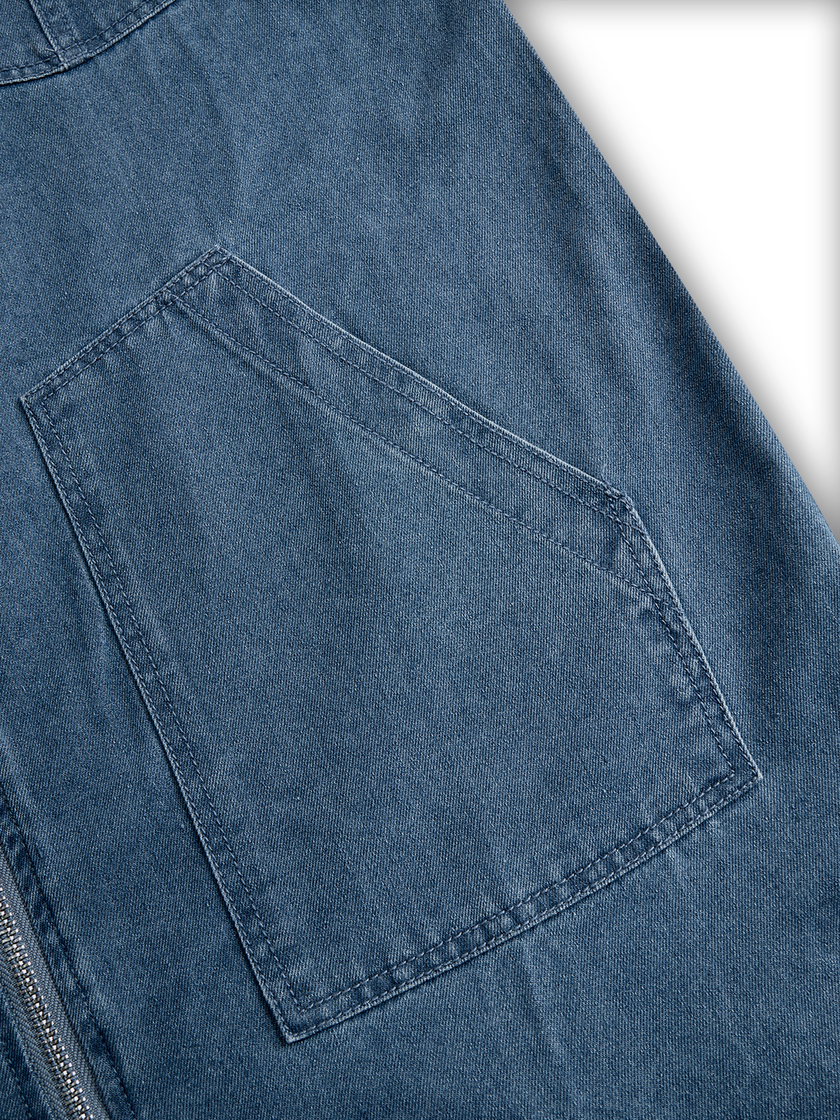 FJØRNA casual loose retro denim jumpsuit with long sleeves, hood, zipper, and front pockets, displayed on a hanger.