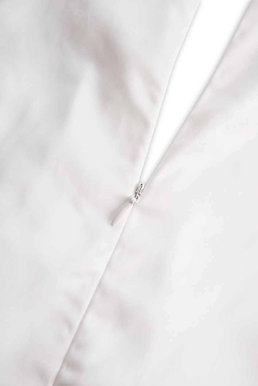 White sleeveless women's blouse with floral embroidery and 3D appliqué, by FJØRNA, showcasing intricate design details.