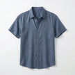 Men's FJØRNA cotton-linen short sleeve shirt with a relaxed fit, featuring a button-up front and classic collar on a plain background.