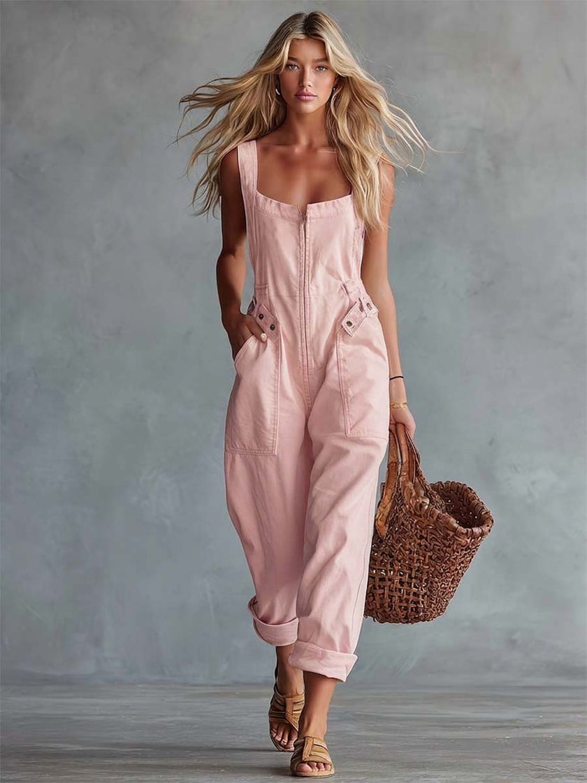 Light yellow denim jumpsuit by FJØRNA featuring a square neckline and zip-front closure, displayed on a hanger.