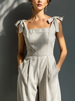Women's striped linen-blend jumpsuit by FJØRNA featuring square neckline, tie straps, and wide-leg pants.