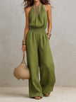 Tan cotton linen sleeveless jumpsuit with halter neck, smocked waist, and wide-leg design by FJØRNA.