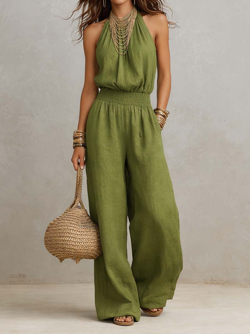 Tan cotton linen sleeveless jumpsuit with halter neck, smocked waist, and wide-leg design by FJØRNA.
