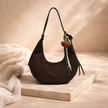 FJØRNA adjustable unisex shoulder bag with sleek design, featuring a strap and compact accessory for women.