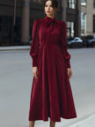 FJØRNA velvet pleated bow-neck midi dress with a fitted waist and elegant pleats, perfect for formal occasions.
