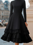 FJØRNA high-neck A-line tiered ruffle midi dress displayed on a model, featuring flowing fabric and layered ruffle details.