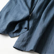 FJØRNA lightweight summer women's trousers with high waist, wide leg, and front pockets, shown in a casual outdoor setting.