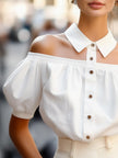 White FJØRNA women's off-shoulder blouse with puff sleeves, button-up front, and statement collar, stylish and elegant top for women.