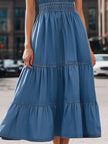 FJØRNA blue halter neck tiered denim maxi dress, sleeveless design with flowing layers, perfect for casual summer wear.