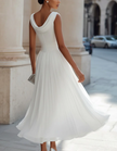 FJØRNA chiffon midi dress for women with draped neckline and pleated design, shown in a flowing, elegant style.