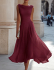 FJØRNA chiffon midi dress for women featuring a draped neckline and pleated design, shown on a model.