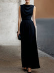 FJØRNA elegant sleeveless maxi dress with draped design and waist definition, showcasing a flowing, sophisticated style.