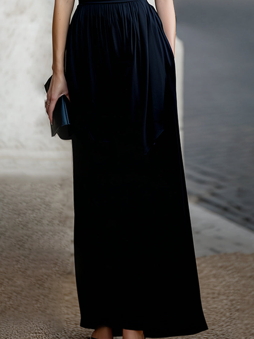 FJØRNA elegant sleeveless maxi dress with draped design and waist definition, perfect for formal occasions.