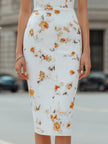 FJØRNA floral print deep V-neck sleeveless bodycon midi dress displayed on a mannequin, showcasing vibrant pattern and fitted style.