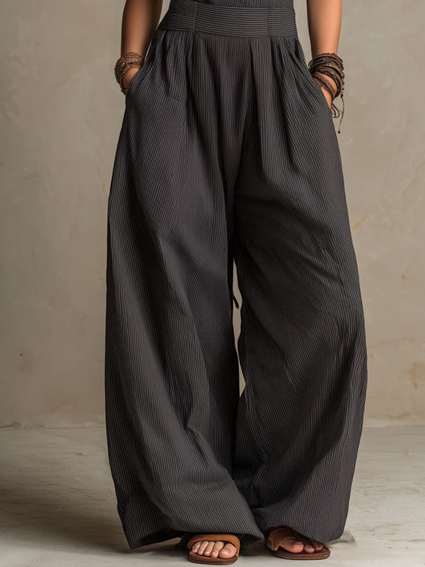 FJØRNA charcoal pinstripe halter neck wide-leg jumpsuit for women, front view showing stylish halter neckline and relaxed wide-leg fit.