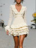 Cream lace ruffle long sleeve tiered mini dress by FJØRNA, featuring delicate lace details and layered skirt design.