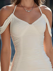FJØRNA cold-shoulder ruched bodycon mini dress with long sleeves and fitted silhouette, shown on a model.