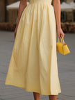 FJØRNA pale yellow spaghetti strap ruched bust flared A-line midi dress, sleeveless with fitted top and flowing skirt.